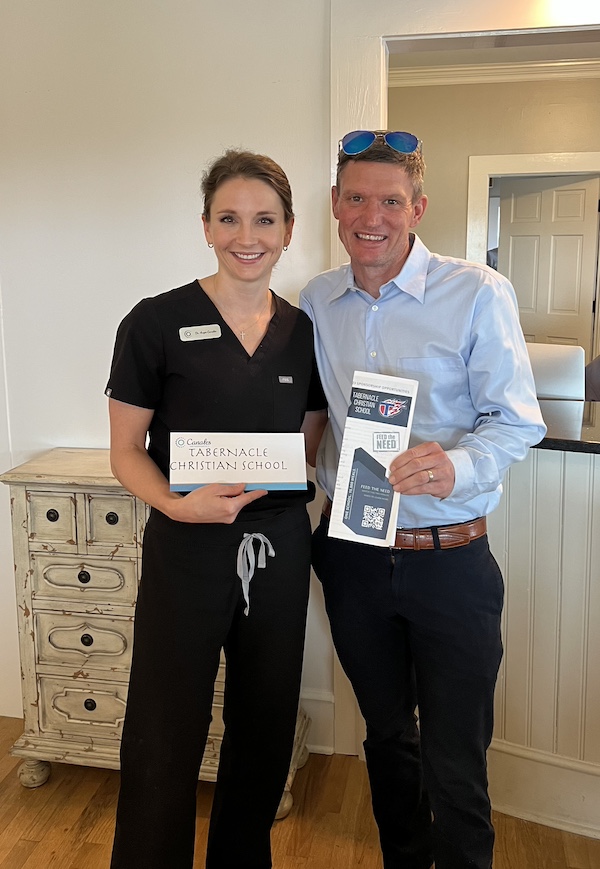 dr angie and man holding hceck