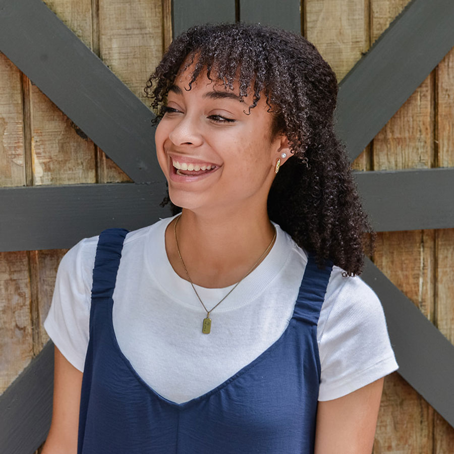 girl-curly-hair-in-front-of-barn