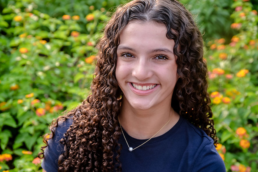 teen girl smiling by flowers